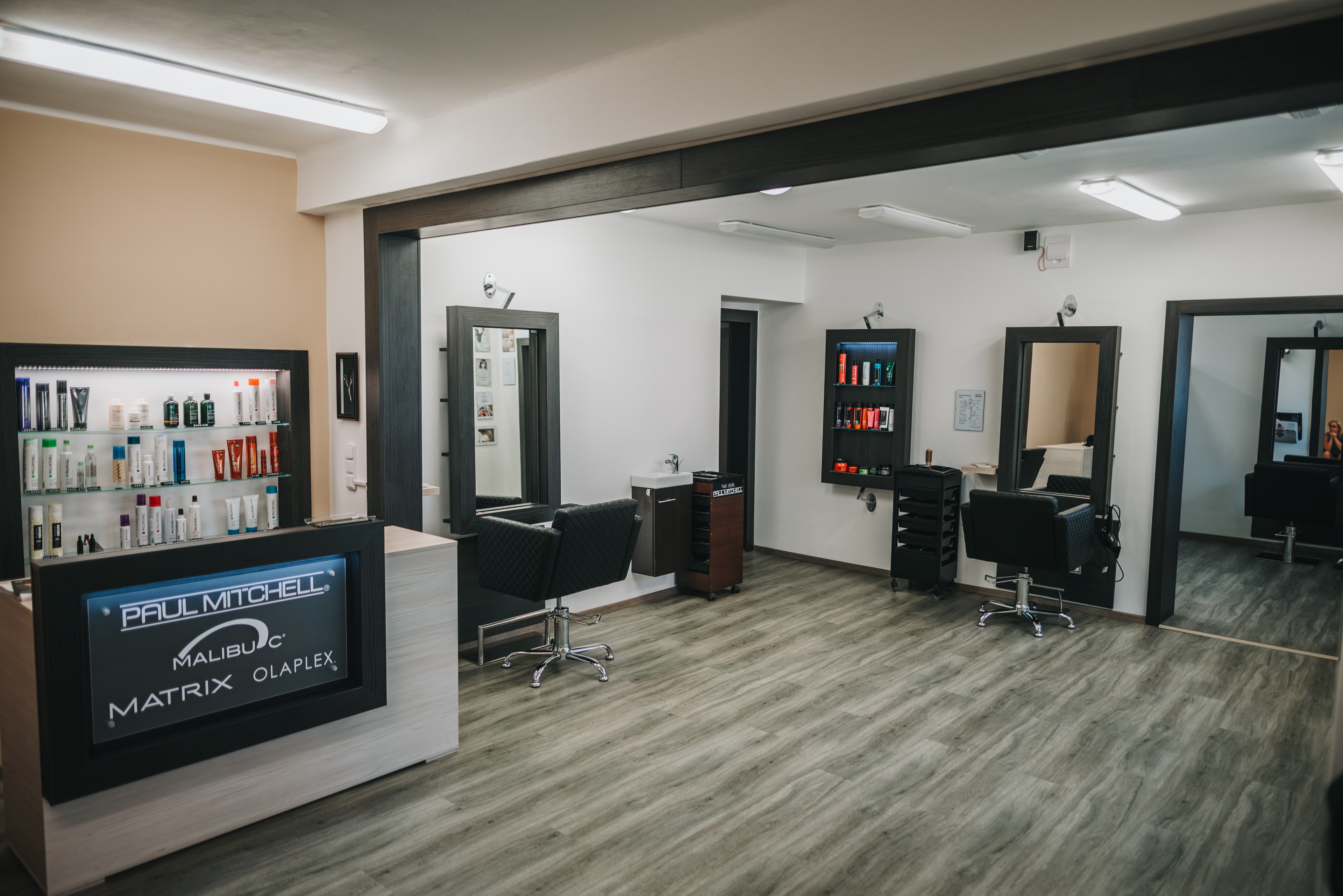 Interiér kadeřnictví Hair4U s recepcí a kadeřnickými místy